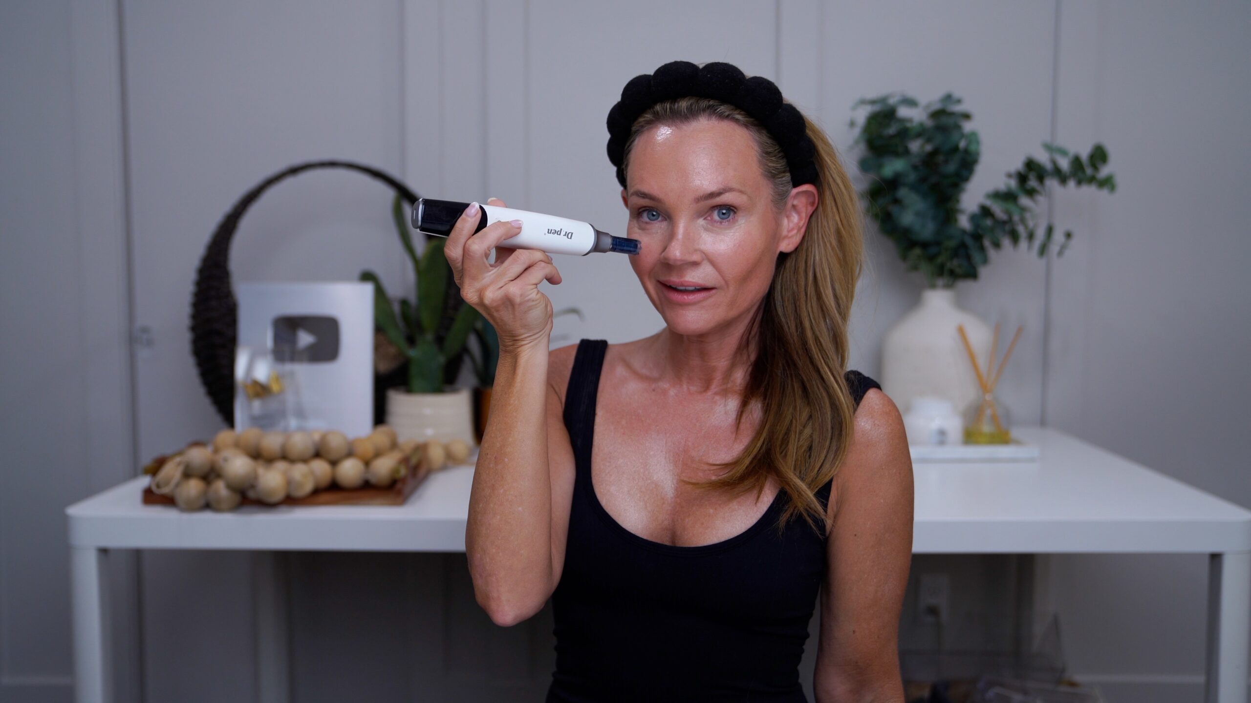 Kim demonstrating at-home microneedling on her cheek
