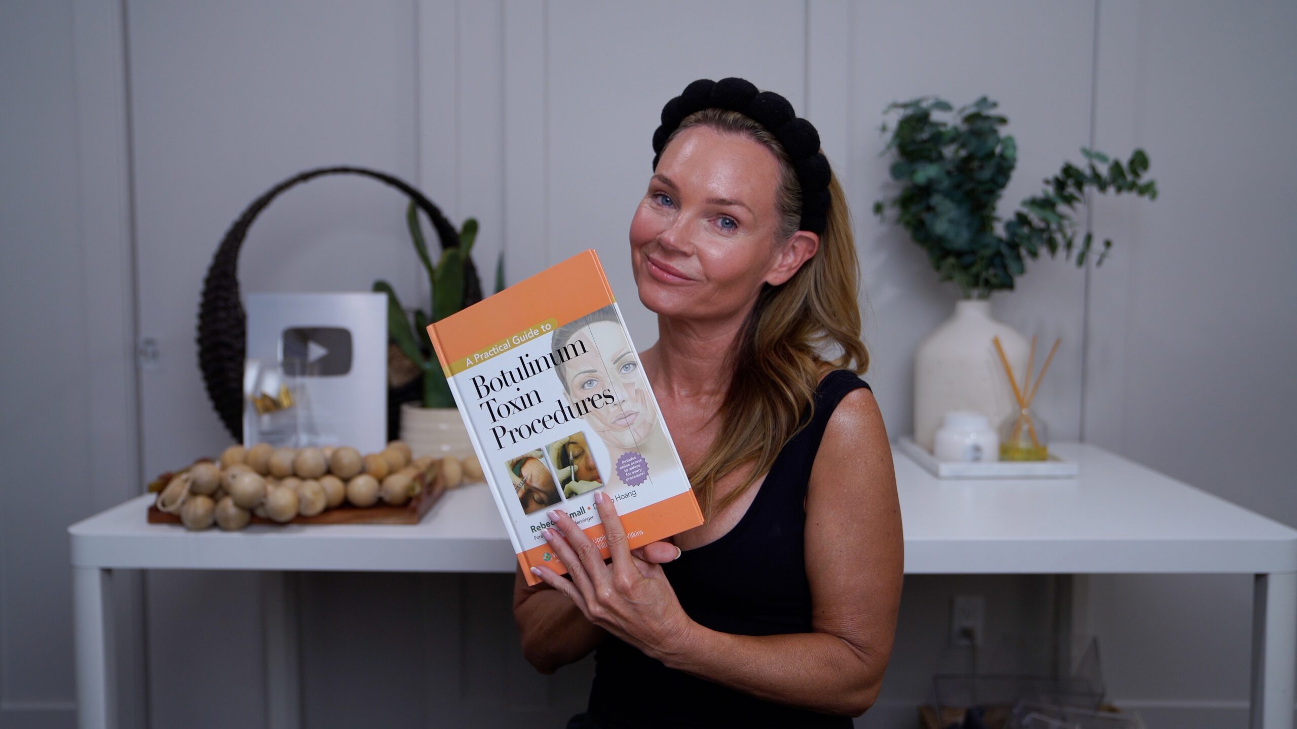 Kim holding an advanced aesthetics reference book