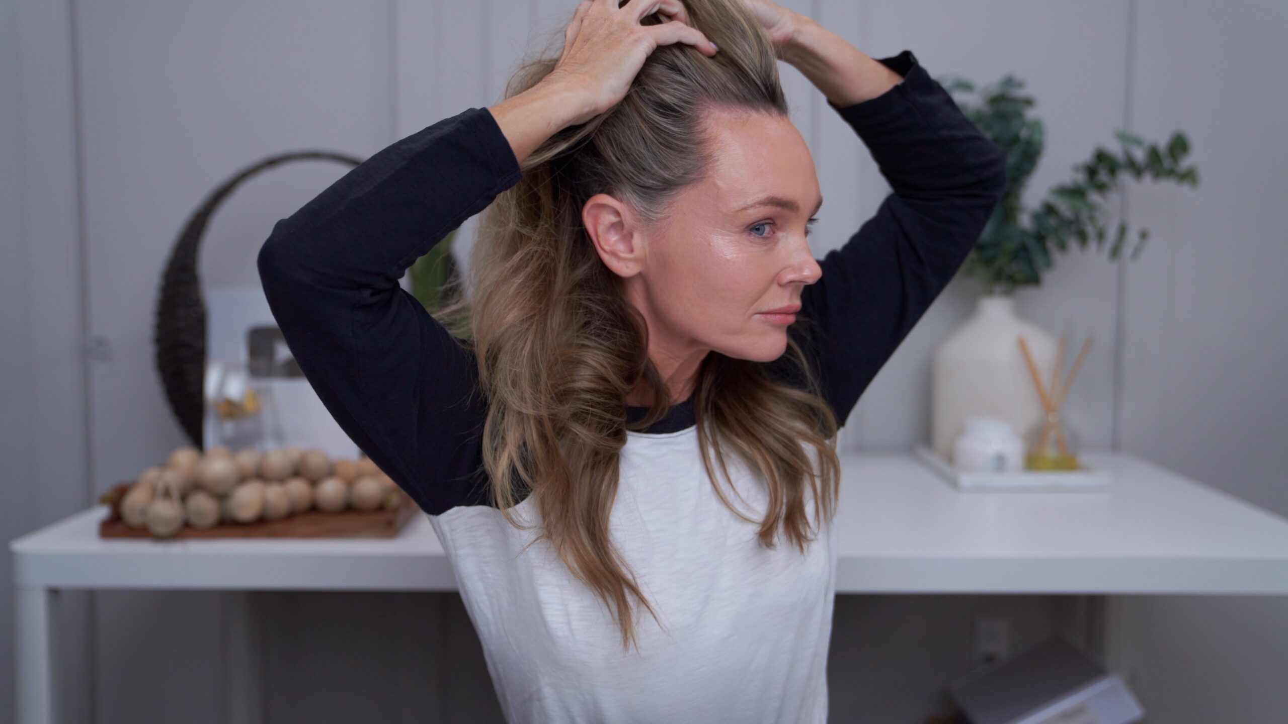 Kim lifting her hair to show her temple and hairline after the documented HairLuma period