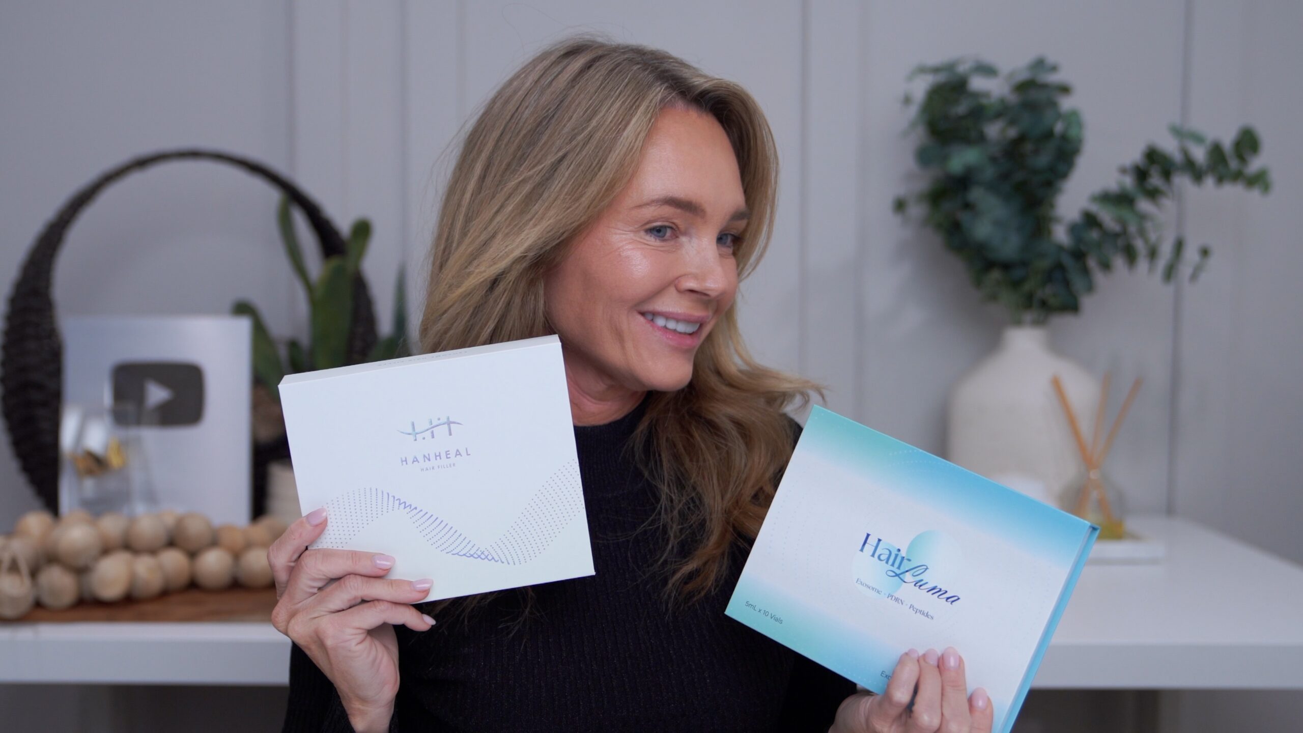 Kim Pratt holding Hanheal Hair Fill and HairLuma scalp-treatment boxes